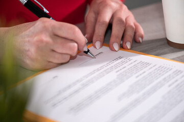 Hand of businesswoman signing a document