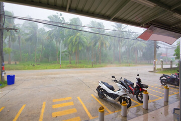 heavy tropical rain with the wind parked near a store on Koh Phangan island in Thailand, a storm in the rainy season