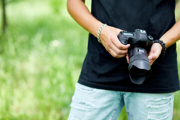 Man photographer with a photo camera in hand outdoor