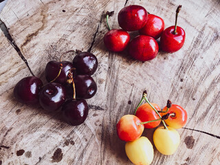 Various kinds of cherry  - garden fruit. Red, Yellow and balck on a wood background