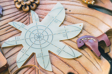 Top view round leather corners stencil ruler cutting template on brown and dark brown leather cow...