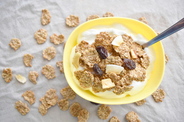 Greek yogurt with fruit and fiber cereal on a bowl. The concept of healthy breakfast, healthy food, dietary plan and weight loss program.  Selective focus.  Copy space is on the left side.