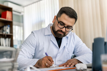 Obraz premium Serious doctor sitting at computer. Medical office. Doctor at work. Diagnosing.