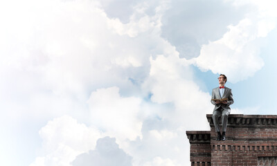 Young businessman or student studying the science on building roof