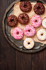 Assorted donuts with chocolate frosted, pink glazed and  vanilla