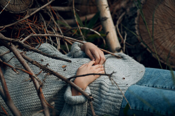 Pretty young woman outdoor in the park under dry tree branches.