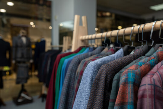 expensive men's clothing store. a row of jackets on hangers. shoping sale background theme. clothes on hanger in shop