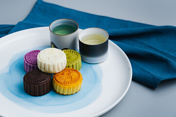 Colorful moon cakes are placed on white plates. Chinese traditional food mid autumn moon cake