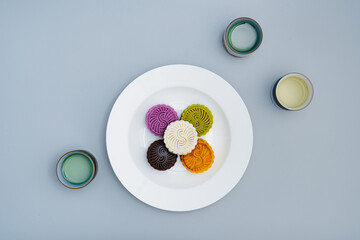 Colorful moon cakes are placed on white plates. Chinese traditional food mid autumn moon cake