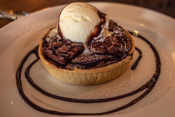 Brownie and cookie dough tarts with ice cream on a plate.