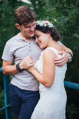 A beautiful couple strolling through the Park. Husband and wife walking in a beautiful Park. The architecture is white. A woman in a white dress on a date. Romance. First love. Tenderness.