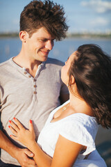 Fototapeta premium A couple in love on the beach. A man and a woman kiss. A couple in love walking on the beach. Date on the beach. Love.