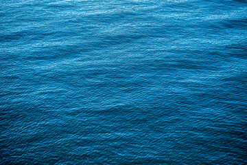 Blue water texture from a surface of a lake that have waves, use for background with some shadows like vignette