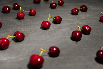 Red cherries on diagonal, in social distancing, on black background. Stay save.