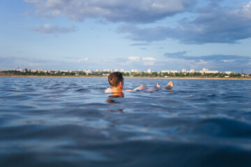 A man is resting on the dead sea. A man is swimming in a salt lake. A man with a beautiful figure swims in the water.