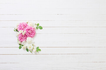 pink and white roses on white wooden background