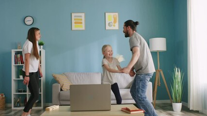 Happy family, mother, father, and girl kid, have fun together at home, dancing and laughing in the morning, jumping, holding each other's hands and making circle, enjoy their lifestyle, Slow motion.