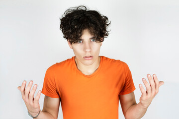 Mixed emotions on the face of a teenage boy, he is angry, surprised, asked and waves his arms. The guy is emotionally communicating with someone