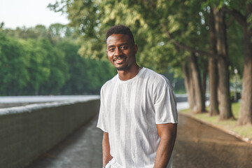 Fototapeta premium Young man smiling at camera in a park. Horizontally framed shot.