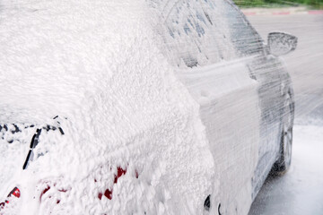 gray cars are washed through a gun with detergent at the sink