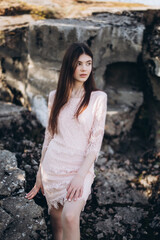 Young brunette girl portrait outdoors in grey mountains outdoors. Woman beauty concept