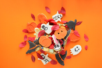 Halloween Jack o Lantern candy bowl with candy and halloween cookies Trick or Treat on orange background