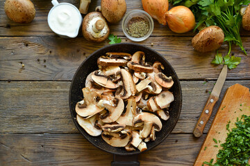 Royal champignons in sour cream sauce. Recipe. Step by step cooking mushrooms with onions. Wood background. Top view. Food in the pan. Fresh mushrooms