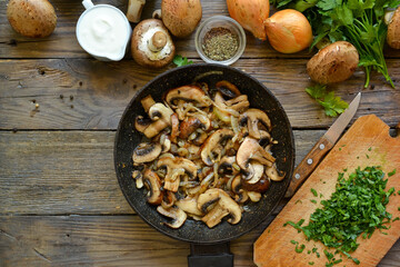 Royal champignons in sour cream sauce. Recipe. Step by step cooking mushrooms with onions. Wood background. Top view. Food in the pan. Fried mushrooms
