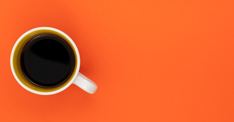 Top view, flat lay of black coffee cup on background orange.