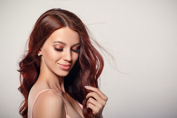 Naklejka premium Studio glamor portrait of a beautiful woman with luxurious hair on a light background.