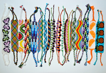 Woven friendship bracelets with alpha and normal patterns handmade of thread on white background