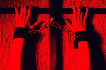 BDSM outfit for adult sex games. Close-up of female hands handcuffed bondsge to the bars