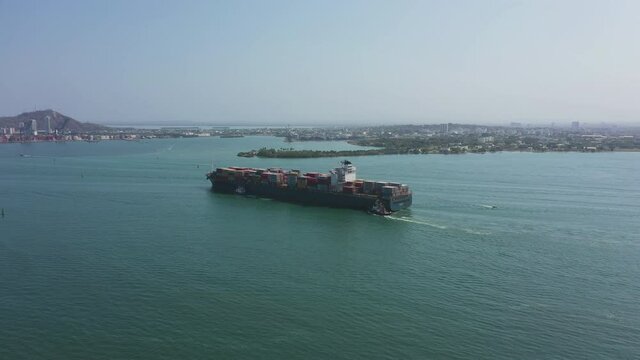 Cargo ship enters the cargo port in Cartagena Colombia aerial view.