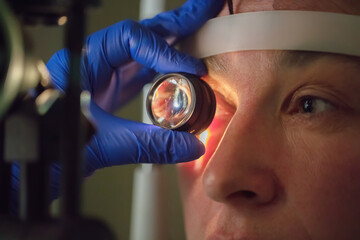 An ophthalmologist checks the fundus of the patient.