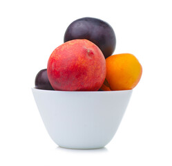 Bowl with fruit apricots, plums, peaches on white background isolation