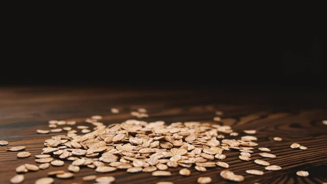 Oatmeal cereal, falling oat flakes, flying oat flakes isolated on black background with slow motion