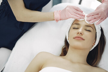 Fototapeta na wymiar Cosmetologist treats client's skin. Woman with cosmetologist. Lady in a beauty studio.