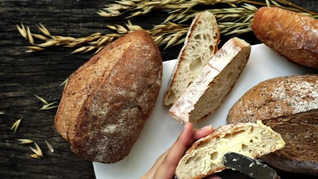 A closeup top view of freshly baked traditional Italian Ciabatta breads prepared and cut in to slices on a wooden table read to be served
