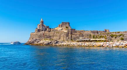 A view looking down the promontory with the church of Saint Peter in Porto Venere, Italy in summertime