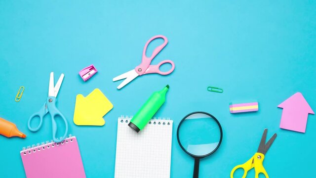Stop motion of school stationery on blue background. Shot in 4k resolution