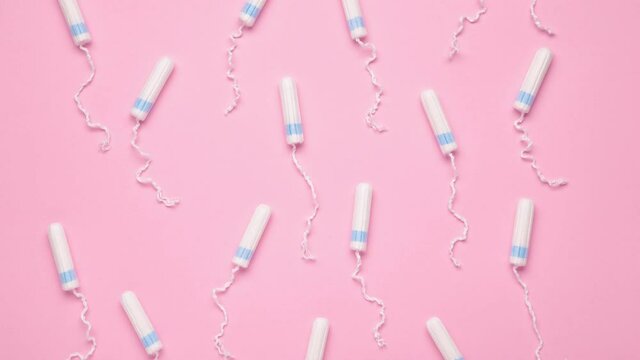 Menstrual tampons move on a pink background. Cotton tampon for women. Top view. Stop motion