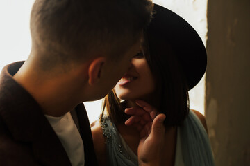 Close up portrait of two lovers looking at each other. They are going to kiss. Stunning sensual outdoor portrait of young stylish couple posing in home.