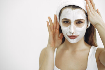 Cosmetology theme. Girl in a white bandage. Woman with mask on face.