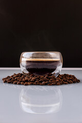 Cup of hot coffee on coffee beans. Vertical photo
