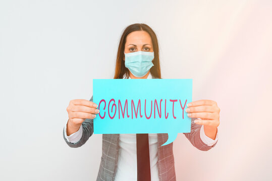 Conceptual hand writing showing Community. Concept meaning group of showing with a common characteristics living together Promoting health awareness with precautionary medical equipment