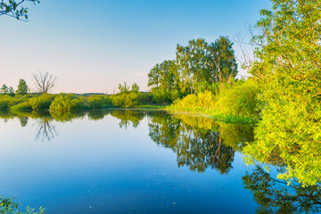 Fototapeta na wymiar Lake water sunset and nature autumn landscape with blue sky