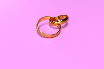 Two golden rings intertwined on a pink background. Wedding. 