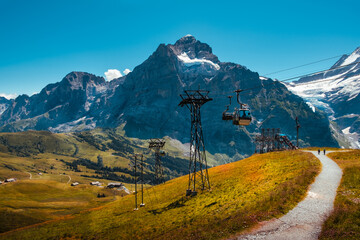 Cable car from Grindelwald to First near the top station in summer and panoramic view on snow...