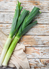 Green leek sultan onion on white wooden table, top view.