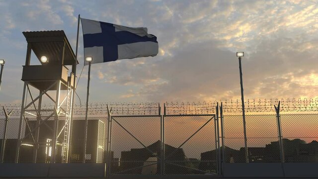 Waving flag of Finland above military base in the evening